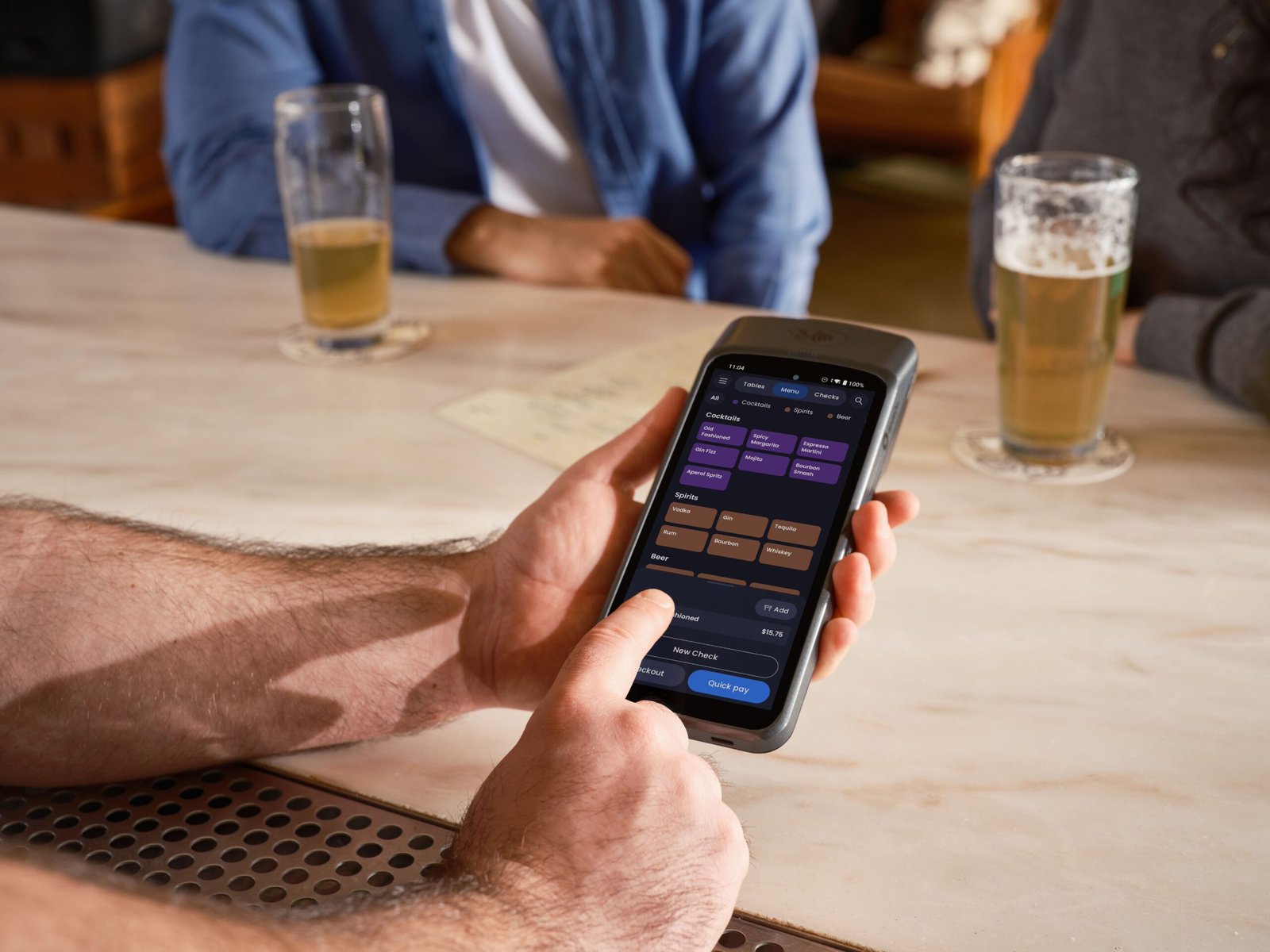 Mesero con terminal POS portátil llevando el cobro a la mesa del cliente en un restaurante moderno.